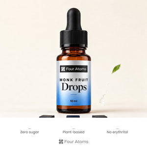Four Atoms monk fruit drops bottle beside a cup of chai